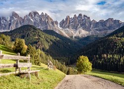 Ławka i płot przy drodze w dolinie Val di Funes z widokiem na Dolomity