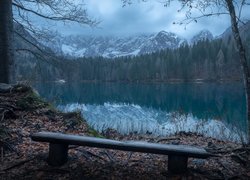 Ławka na brzegu jeziora z widokiem na ośnieżone góry