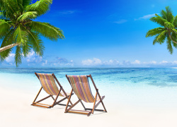 Leżaki na morskiej plaży z palmami