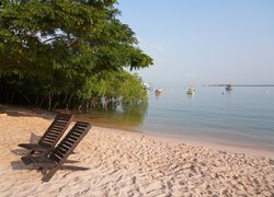 Leżaki na plaży i łodzie na morzu