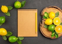 Limonki i cytryny obok notesu