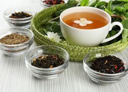 Liściaste herbaty w miseczkach obok filiżanki