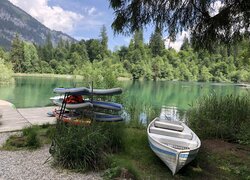 Łódka i deski surfingowe przy pomoście nad górskim jeziorem