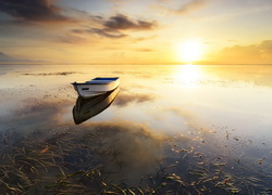 Łódka na jeziorze w blasku zachodzącego słońca
