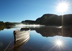 Łódka na jeziorze w promieniach słońca