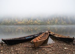 Łódki na brzegu zamglonego jeziora