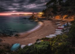 Łódki na hiszpańskiej plaży w Lloret de Mar wieczorową porą