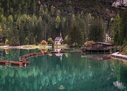 Łódki na jeziorze Pragser Wildsee i kościół na tle lasu we włoskich Dolomitach