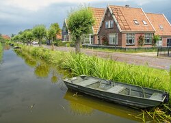 Łódki na kanale obok domów przy drodze w miasteczku