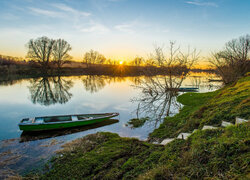 Łódki na rzece w blasku zachodzącego słońca