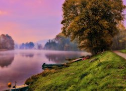 Łódki nad brzegiem jeziora we mgle