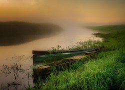 Łódki przy brzegu rzeki we mgle