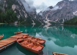 Łódki przy pomoście na jeziorze Pragser Wildsee we włoskich Dolomitach