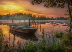 Łódź na jeziorze w blasku wschodzącego słońca