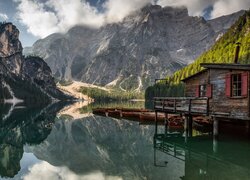 Łodzie i dom na pomoście na jeziorze Pragser Wildsee w Dolomitach