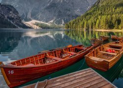 Łodzie na brzegu jeziora Lago di Braies i kościół w oddali