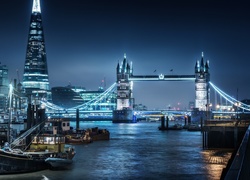 Londyński most Tower Bridge nad Tamizą ze statkami oświetlony nocą