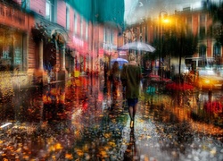 Ludzie pod parasolami na ulicy w deszczu