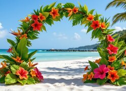 Łuk udekorowany kolorowymi kwiatami na morskiej plaży