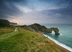 Łuk wapienny, Durdle Door, Wybrzeże Jurajskie, Skały, Trawa, Chmury, Zachód słońca, Hrabstwo Dorset, Anglia