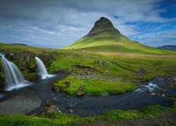 Mały wodospad Kirkjufellsfoss i góra Kirkjufell w oddali