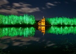 Mały zamek i oświetlone drzewa w ogrodzie Oakfield Park