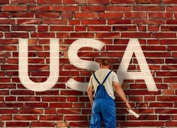 Mężczyzna malujący napis USA na murze