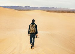 Mężczyzna z aparatem fotograficznym na pustyni