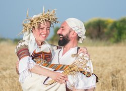 Mężczyzna z kobietą na rękach w polu pszenicy