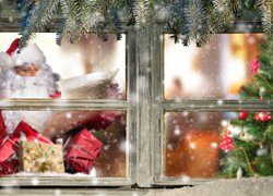 Mikołaj z prezentami i choinka za oknem