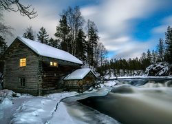 Młyn Myllykoski w śniegu nad rzeką w gminie Kuusamo w Finlandii
