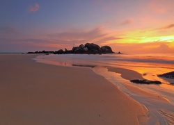 Morska plaża i skały w blasku zachodzącego słońca