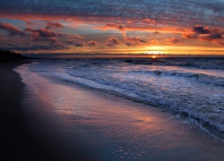Morskie fale przy brzegu w blasku zachodzącego słońca