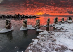 Morze i zaśnieżone skały o zachodzie słońca