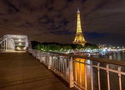 Most Passerelle Debilly z widokiem na wieżę Eiffla nocą