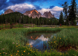 Mostek nad jeziorem Antorno Lake i masyw Tre Cime di Lavaredo pod chmurami