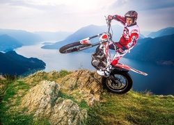 Motocyklista wykonujący stunt na wzgórzu