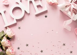 Napis Love obok prezentu i róż