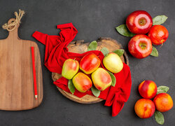 Nektarynki obok jabłek na desce