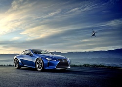 Niebieski hybrydowy Lexus LC 500h i helikopter w tle