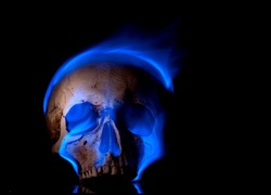 Niebieski płomień oświetla czaszkę