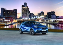 Niebieski Renault Captur na tle wieżowców