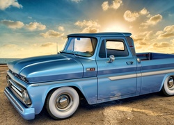 Niebieski samochód marki Chevrolet C10 rocznik 1965 na tle pochmurnego nieba