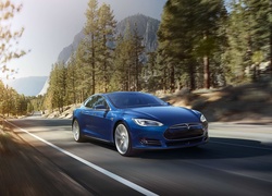 Niebieskie auto Tesla Model S 70D z 2015 roku mknące szosą