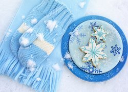 Niebieskie rękawiczki i szalik obok talerza z ciasteczkami