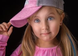 Niebieskooka dziewczynka w różowej czapce z daszkiem