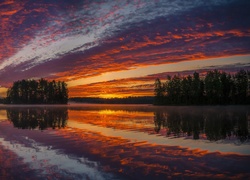 Niebo przegląda się w jeziorze o zachodzie słońca