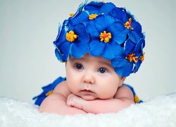Niemowlę w czapce z niebieskich kwiatów