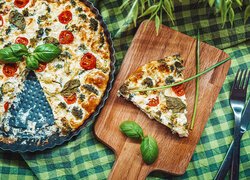 Nóż i widelec obok pizzy na tacy i desce