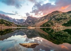 Odbicie chmur i skalistych gór w jeziorze